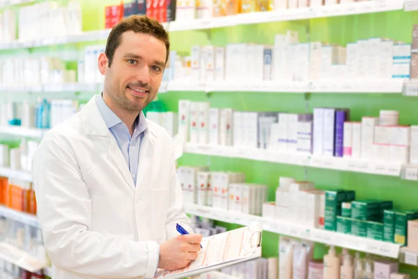 Aantrekkelijke apotheker notities op het werk — Stockfoto