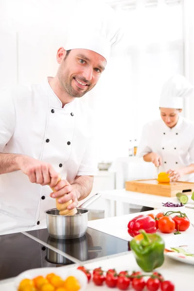 Young attractive professional chef cooking in his kitchen — Stock Photo, Image