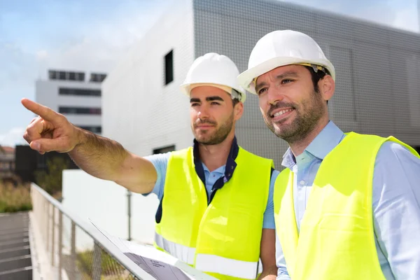 Worker and architect watching some details on a construction — Stock Photo, Image