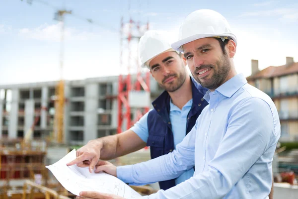 mühendis ve işçi blueprint inşaat sitesinde izliyor