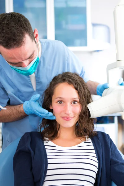 Young attractive dentist doing a radiography of woman teeth — Stock Photo, Image