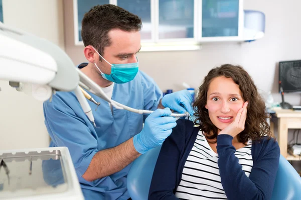 Młoda atrakcyjna kobieta boi się leczony przez stomatologa — Zdjęcie stockowe