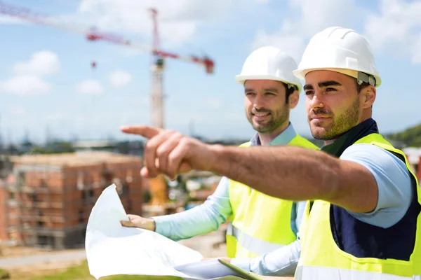 Arbetare och arkitekt tittar några detaljer på en konstruktion — Stockfoto