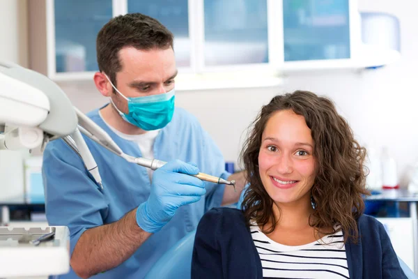 Jovem mulher atraente sendo curada por um dentista — Fotografia de Stock