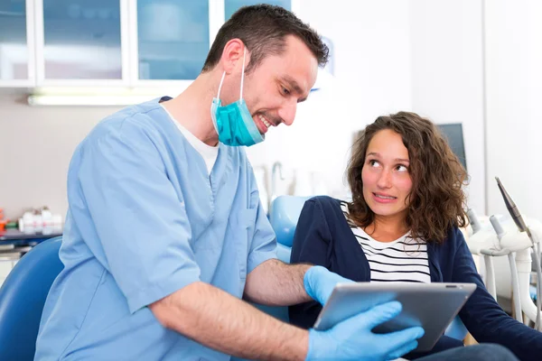 Mujer atractiva joven asustada de ser curada por un dentista — Foto de Stock