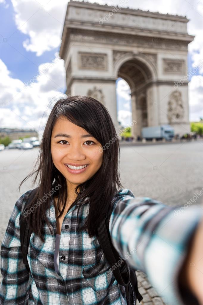 Young attractive asian tourist in Paris taking selfie