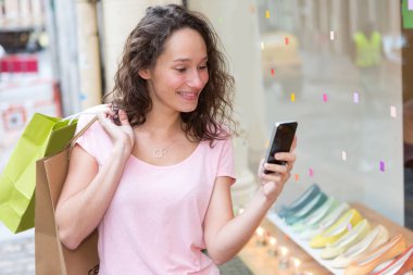 Alışveriş sırasında telefon kullanan genç çekici kadın