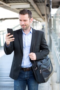 Smartphone kullanarak genç çekici iş adamı