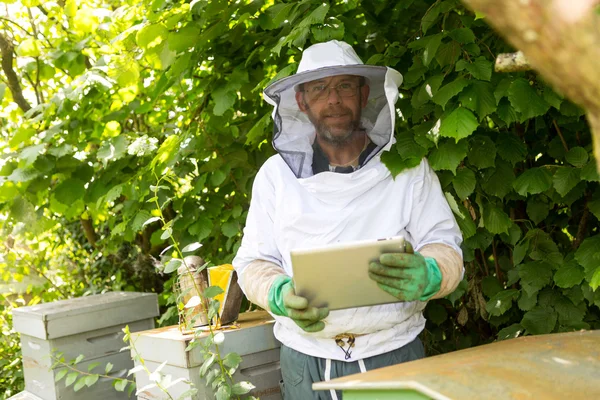 Imker behandeling een tablet voor bijenkorven — Stockfoto