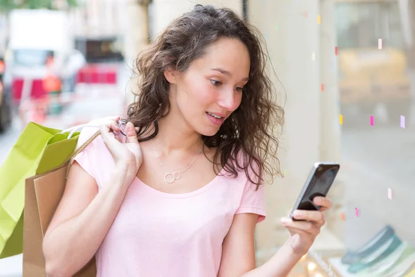 Giovane donna attraente utilizzando cellulare durante lo shopping — Foto Stock
