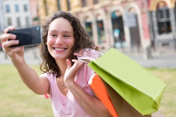 Genç çekici bir kadın alışveriş yaparken selfie çekiyor. — Stok fotoğraf