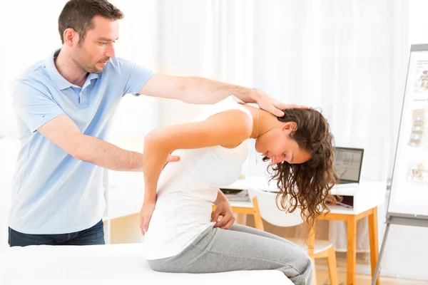 Joven mujer atractiva siendo manipulada por fisioterapeuta — Foto de Stock