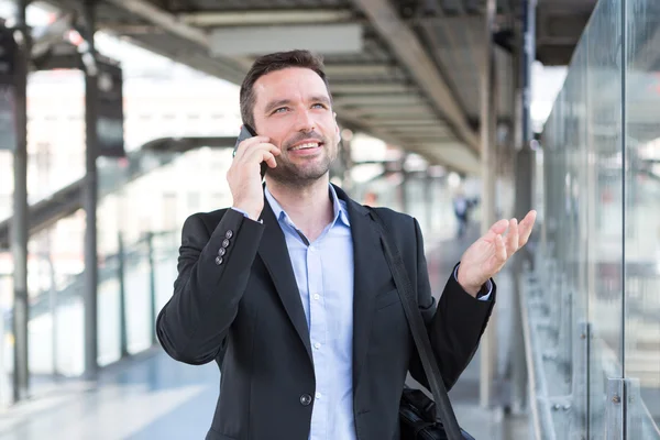 Jonge aantrekkelijke zakenman gebruikend smartphone — Stockfoto