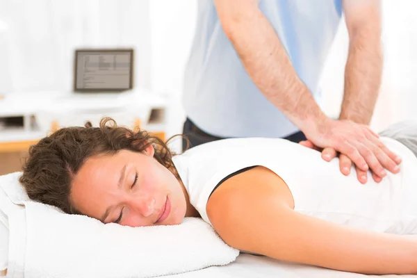 Young attarctive woman being manipulated by physiotherapist — Stock Photo, Image