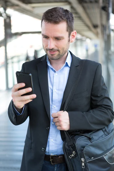 Jonge aantrekkelijke zakenman gebruikend smartphone — Stockfoto