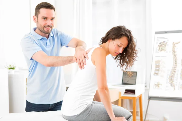 Young attractive woman being manipulated by physiotherapist — Stock Photo, Image