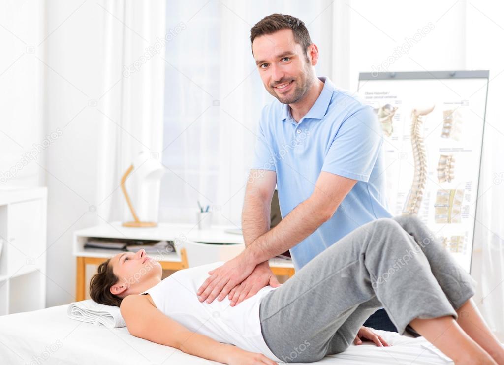 Young attractive woman being manipulated by physiotherapist