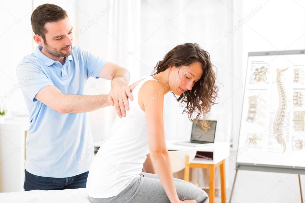 Young attractive woman being manipulated by physiotherapist