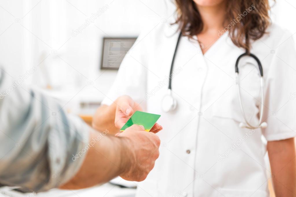 Young attractive doctor taking health insurance card