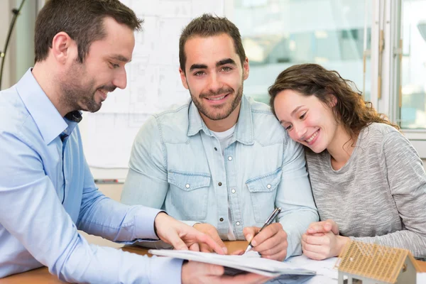 Young attractive people signing cotract with meeting real estate — Stock Photo, Image