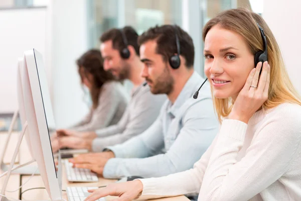 Jovem mulher atraente trabalhando em um call center — Fotografia de Stock