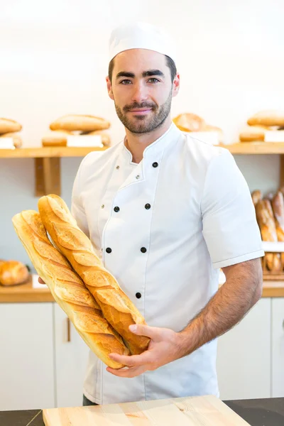 Young attarctive baker working at the bakery — Stock Photo, Image