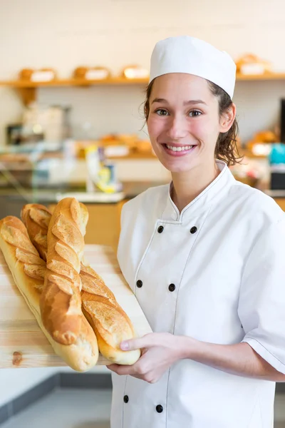 Junge Bäckerin arbeitet in der Bäckerei — Stockfoto