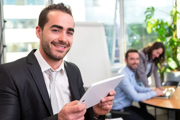 Junger attraktiver Geschäftsmann arbeitet im Büro mit Associat — Stockfoto