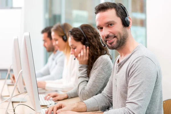 Giovane uomo attraente che lavora in un call center — Foto Stock