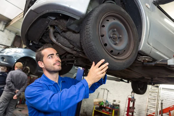 Mladá atraktivní mechanik pracuje na auto v garáži — Stock fotografie