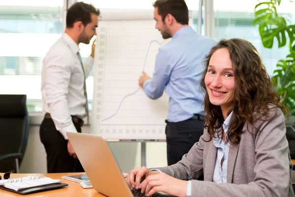 Young attractive businesswoman working at the office with associ — Stock Photo, Image