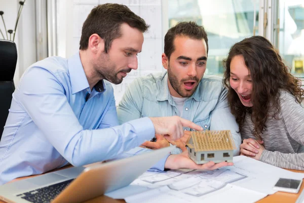 Young attractive people meeting real estate agent at the office — Stock Photo, Image