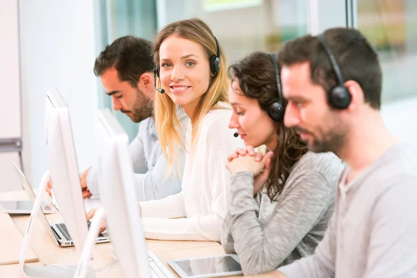 Giovane donna attraente che lavora in un call center — Foto Stock