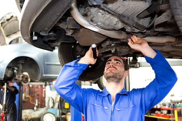 Mladá atraktivní mechanik pracuje na auto v garáži — Stock fotografie