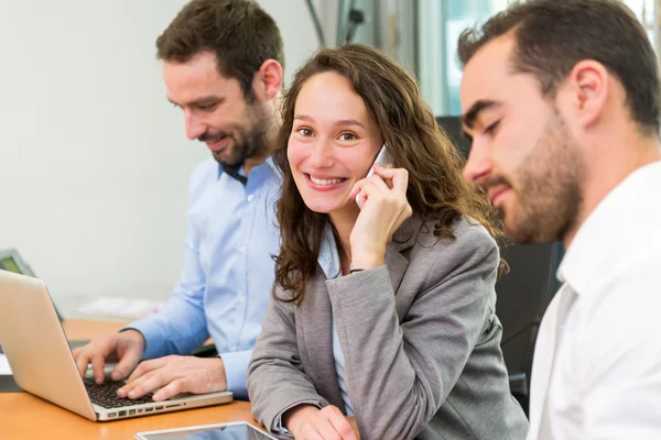 Junge attraktive Geschäftsfrau arbeitet im Büro mit associ — Stockfoto