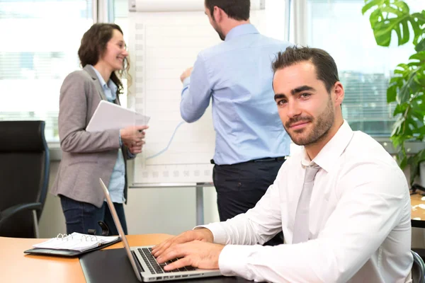 Young attractive businessman working at the office with associat — Stock Photo, Image