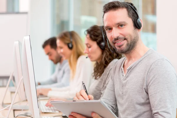 Giovane uomo attraente che lavora in un call center — Foto Stock