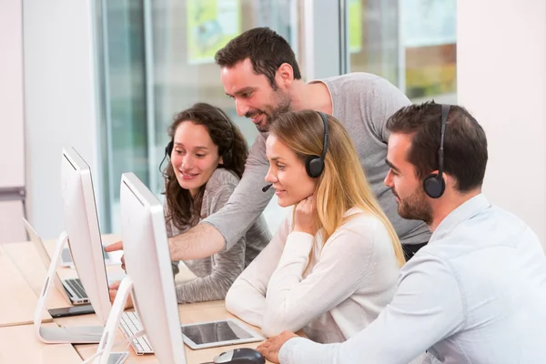 Young attractive people learning their new job at call center — Stock Photo, Image