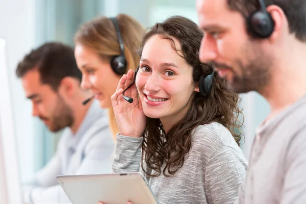 Jonge aantrekkelijke vrouw die werkt in een callcenter — Stockfoto