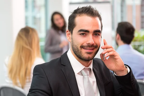 Jovem empresário atraente que trabalha no escritório com associado — Fotografia de Stock