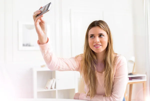 Jonge aantrekkelijke vrouw nemen selfie thuis — Stockfoto