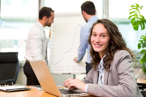 Junge attraktive Geschäftsfrau arbeitet im Büro mit associ — Stockfoto