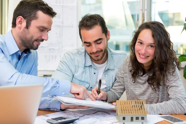 Jóvenes atractivos firman contrato con la reunión de bienes raíces — Foto de Stock