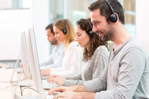 Young attractive man working in a call center — Stock Photo, Image