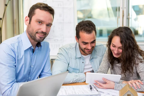 Jeunes gens attrayants rencontrer agent immobilier au bureau — Photo