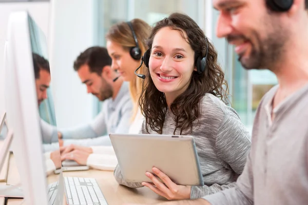 Jovem mulher atraente trabalhando em um call center — Fotografia de Stock