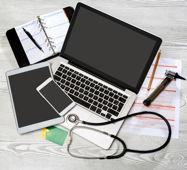 Bureau de médecin en bois en haute définition avec ordinateur portable, tablette et mo — Photo