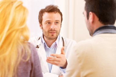 Genç çekici doktor hastaların genç bir çift danışmanlık