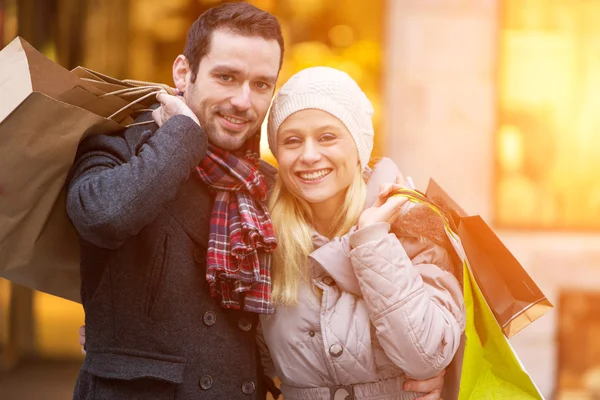 Jonge aantrekkelijke paar met shopping tassen — Stockfoto