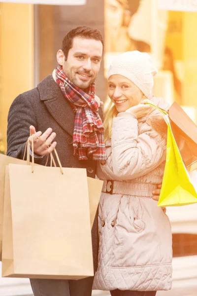 ショッピング バッグと若い魅力的なカップル — ストック写真